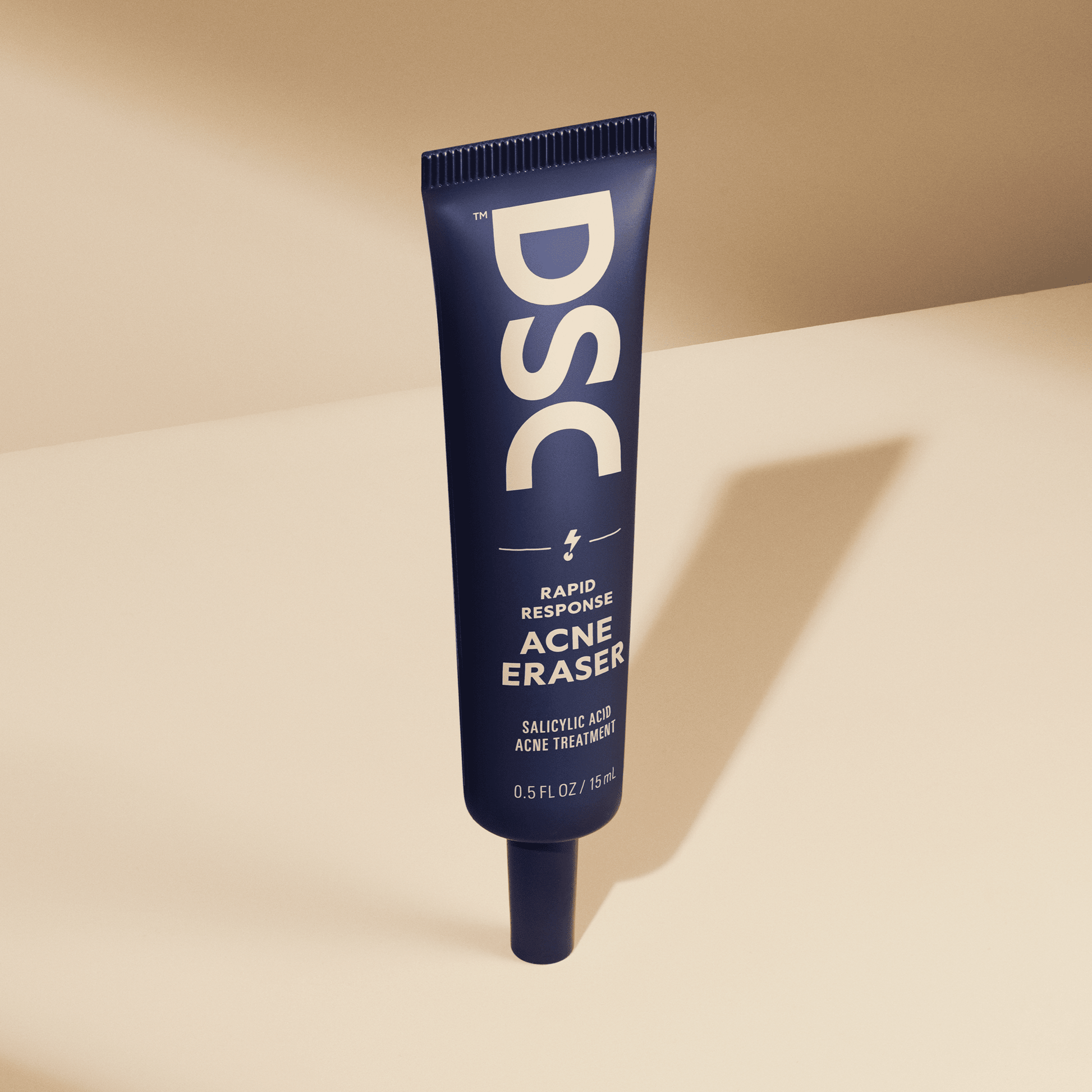 Dollar Shave Club Acne Eraser against tan backdrop.