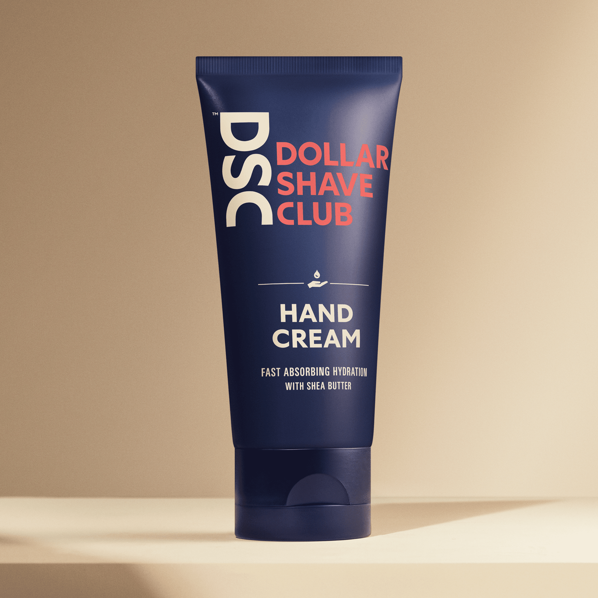 Dollar Shave Club Hand Cream against tan backdrop.